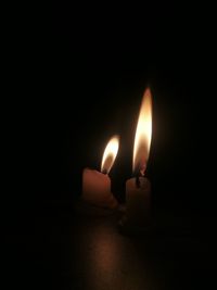 Close-up of burning candle in darkroom