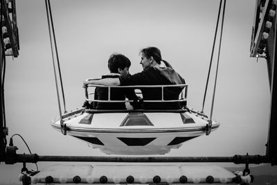 Mother with son sitting in amusement park ride