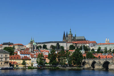 Buildings at waterfront against blue sky