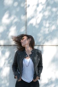 Young woman standing against sky