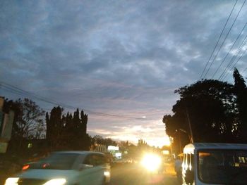 Cars on road against sky during sunset