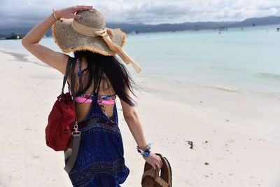 Woman wearing straw hat on beach