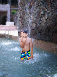 Full length of shirtless boy in water