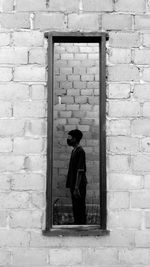 Side view of man standing against wall