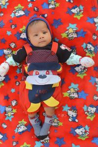 High angle view of cute baby lying on bed