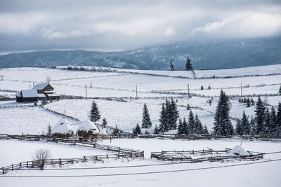 Snow covered land and mountains against sky