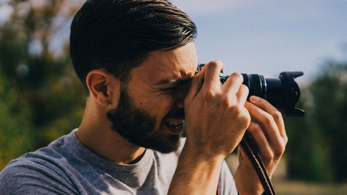 Photographer taking picture by digital camera outdoors