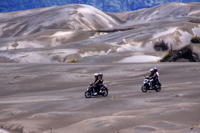 People riding motorcycles on rock formations in desert