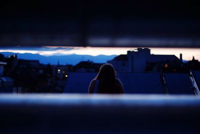 Woman looking at illuminated city at night