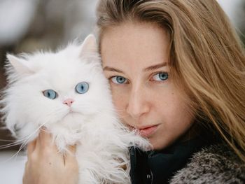 Portrait of smiling young woman with cat