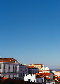 Buildings in city against clear blue sky