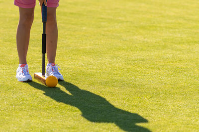 Low section of woman with ball on grassland