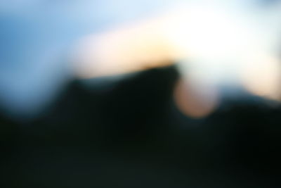 Defocused image of silhouette tree against sky