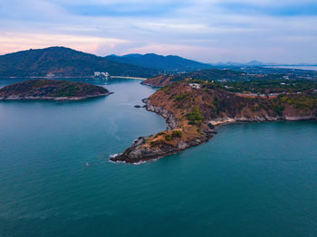 Scenic view of sea and mountains against sky