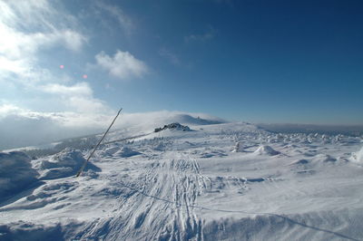 Snow covered landscape against sky