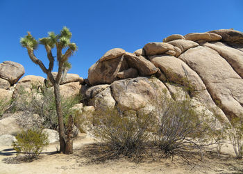 Low angle view of rock formation against clear blue sky