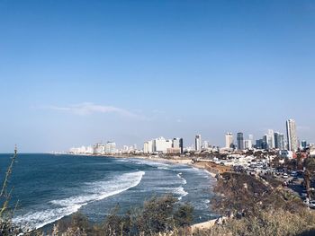 Scenic view of sea and buildings against blue sky