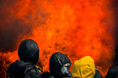 Rear view of firefighters against fire