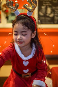 Close-up of cute girl wearing costume sitting at restaurant
