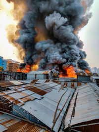 Fire by buildings against sky