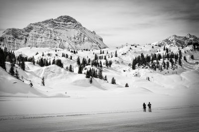 Tourists on snow covered mountain