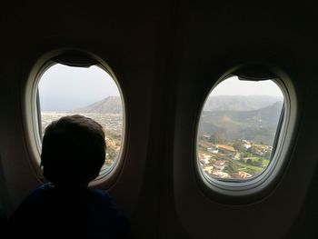 Silhouette man seen through airplane window
