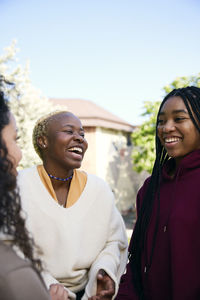 Cheerful young female friends talking to each other