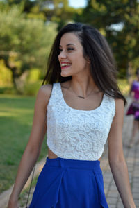 Beautiful young woman smiling while standing against blurred background