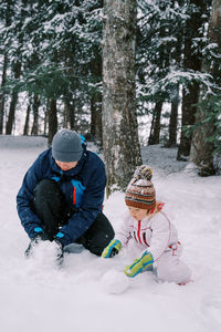 Rear view of woman skiing on snow covered field