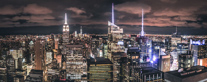 Illuminated cityscape against sky at night