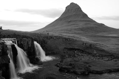 Waterfall against rocky peak