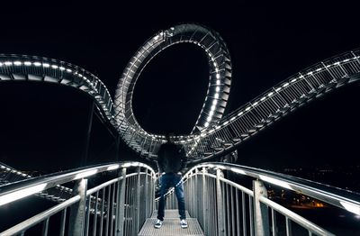 Low angle view of illuminated bridge against sky at night