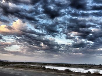 Scenic view of beach against dramatic sky
