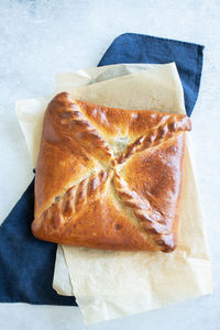 Freshly baked meat pie on a parchment paper on table background. pie with meat and mushrooms. 