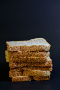 Close-up of bread stack against black background