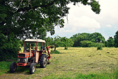 Tractor on agricultural field against sky