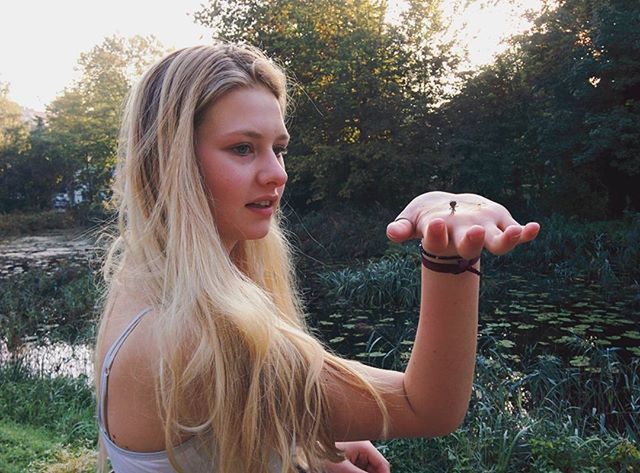 person, childhood, girls, leisure activity, lifestyles, tree, elementary age, smiling, casual clothing, blond hair, happiness, park - man made space, looking at camera, front view, portrait, innocence, long hair, cute