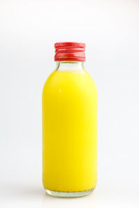 Close-up of yellow bottle against white background