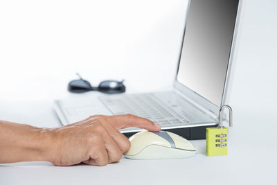 Close-up of man using laptop on table