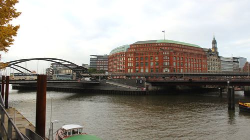 Bridge over river in city against sky