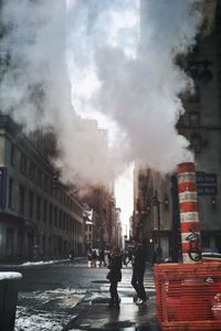 Buildings in city against cloudy sky