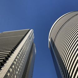 Low angle view of modern buildings against clear blue sky