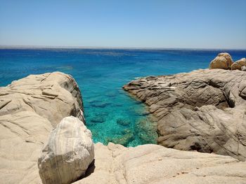 Scenic view of sea and rock formations against clear sky