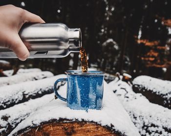 Close-up of person hand holding ice cream in snow