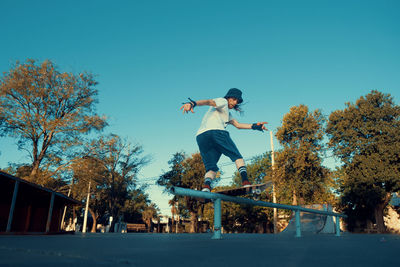 Low angle view of man skateboarding on field