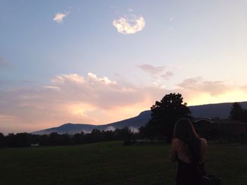 Scenic view of grassy field against cloudy sky