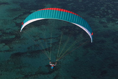 High angle view of man paragliding over sea