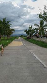 Empty road against cloudy sky