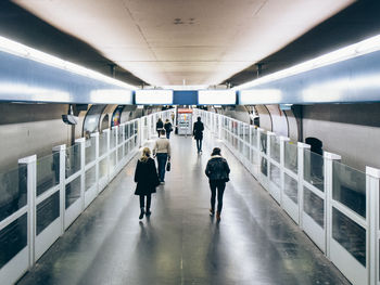Rear view of people walking at railway station platform