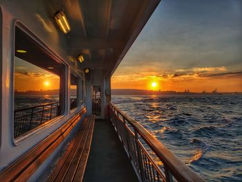 Illuminated bridge over sea against sky during sunset